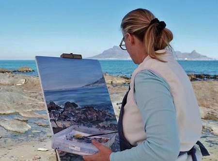 Artist on beach painting landscape